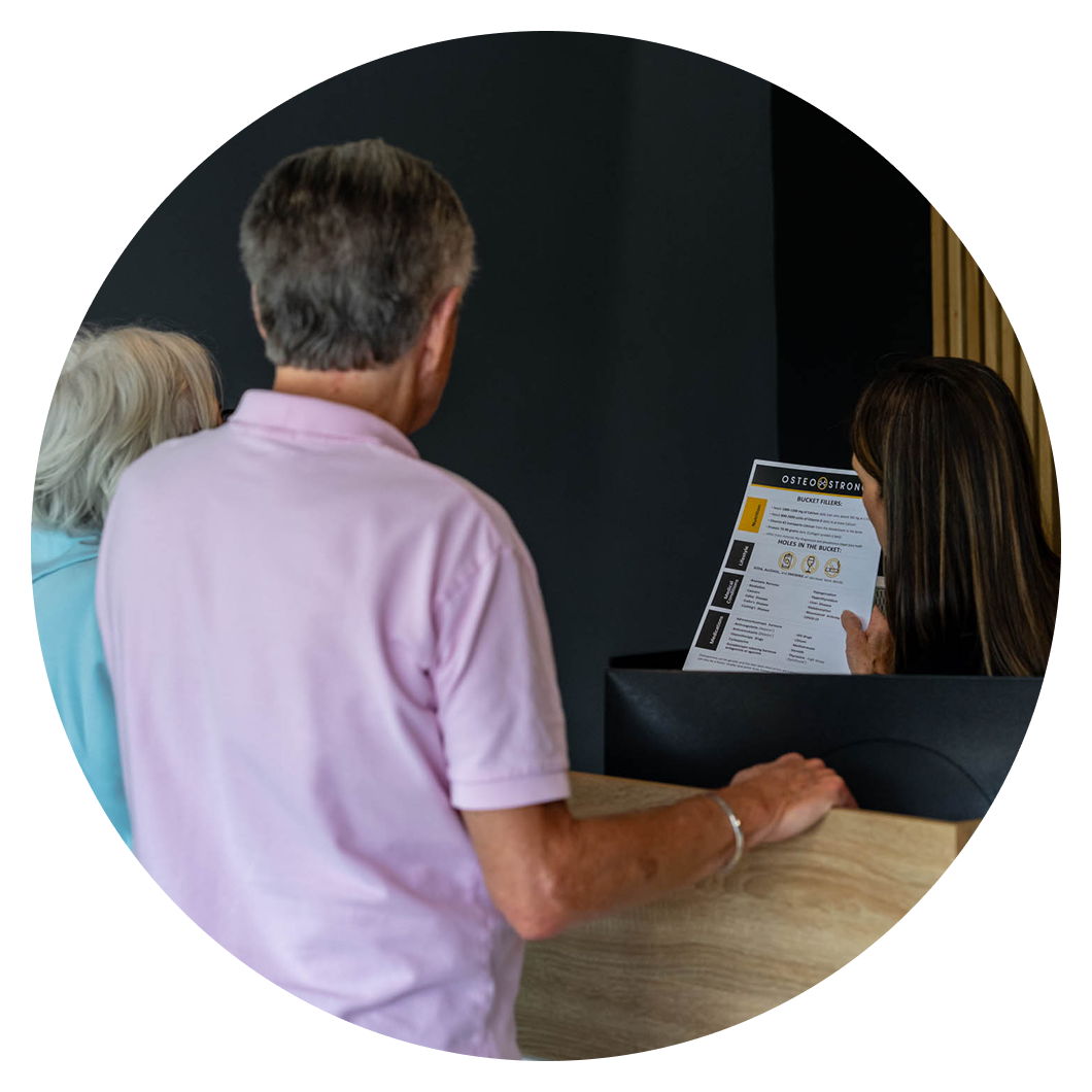 People at a reception desk reviewing leaflet.