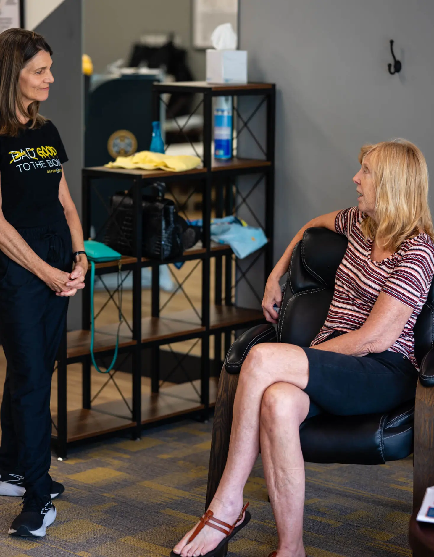 Two women conversing in physical therapy clinic